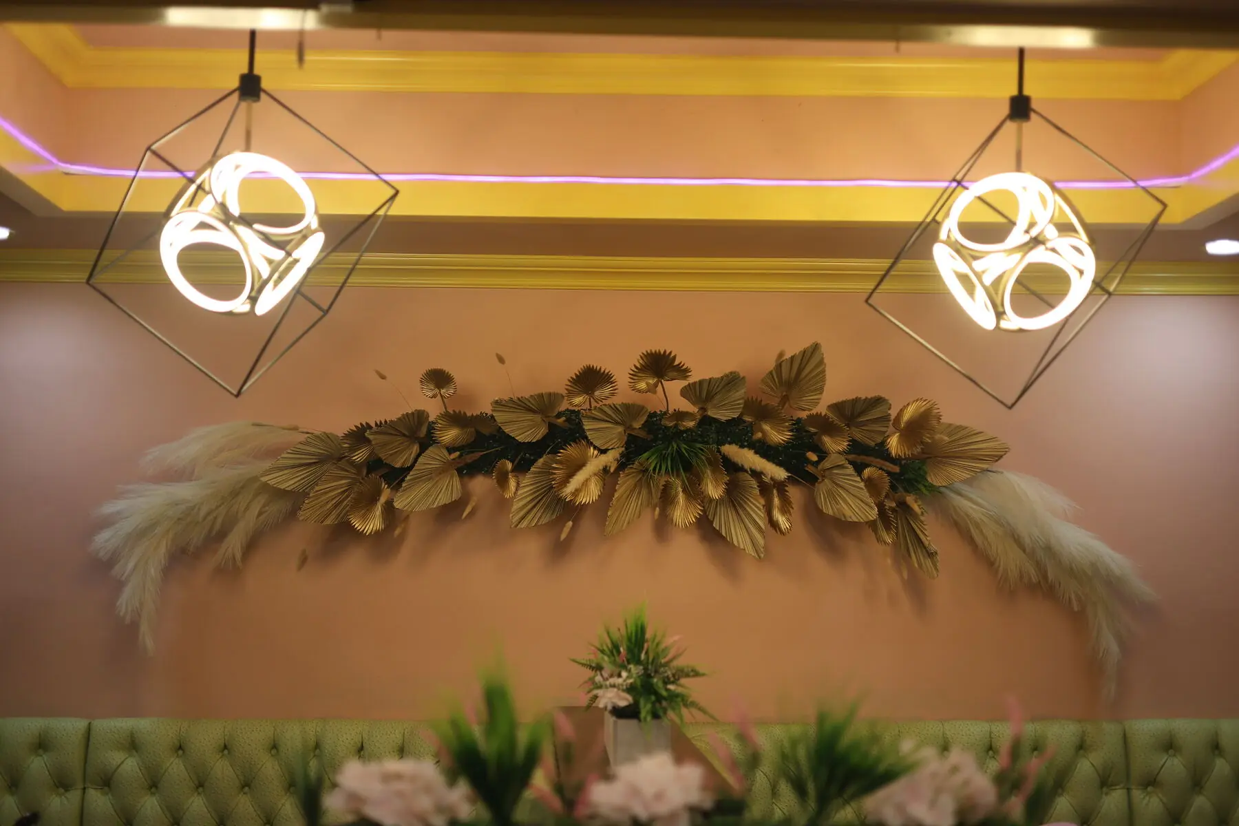 Gold leaf wall art beneath sculptural lighting