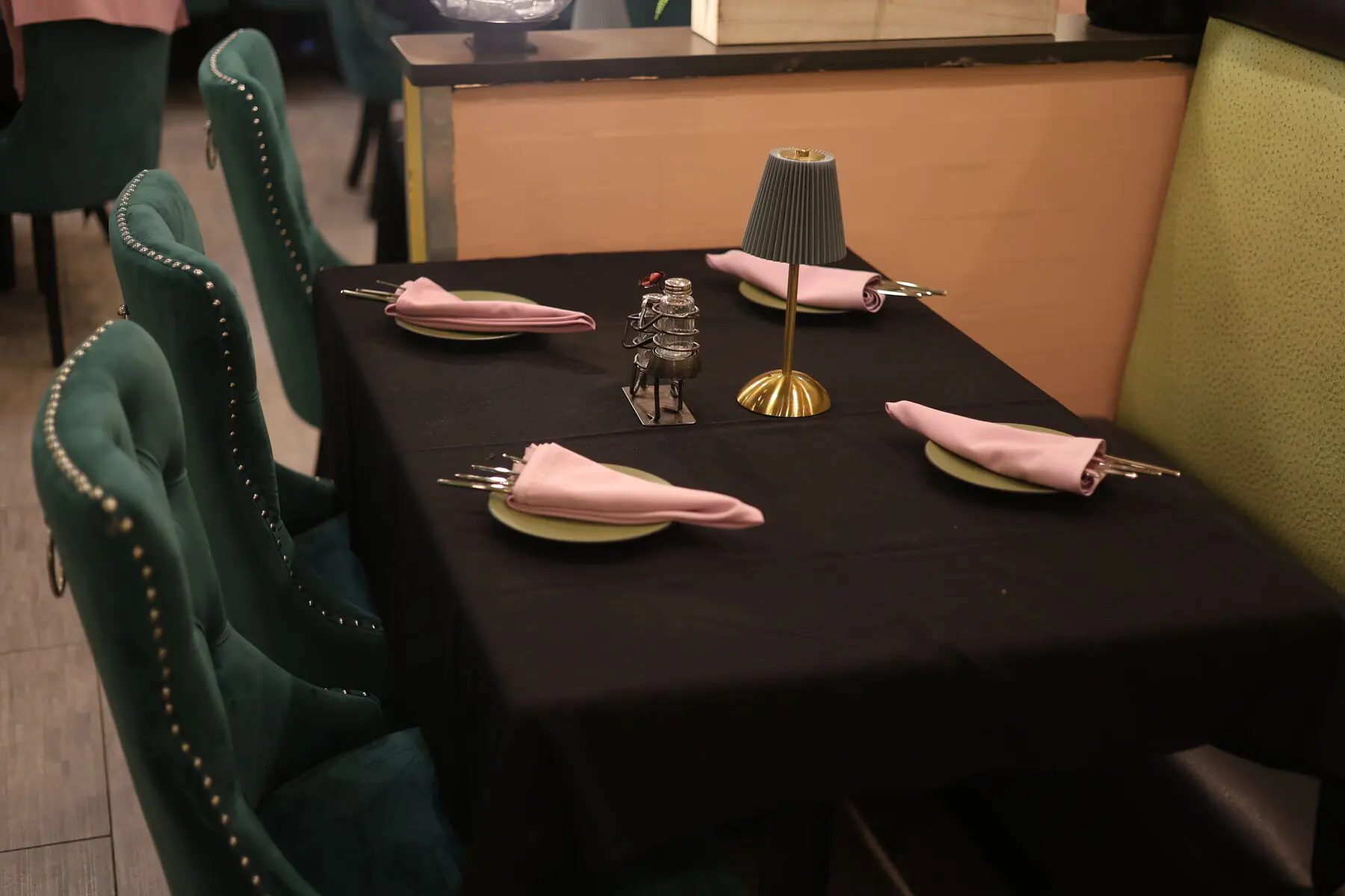 Table set for dinner with green velvet chairs